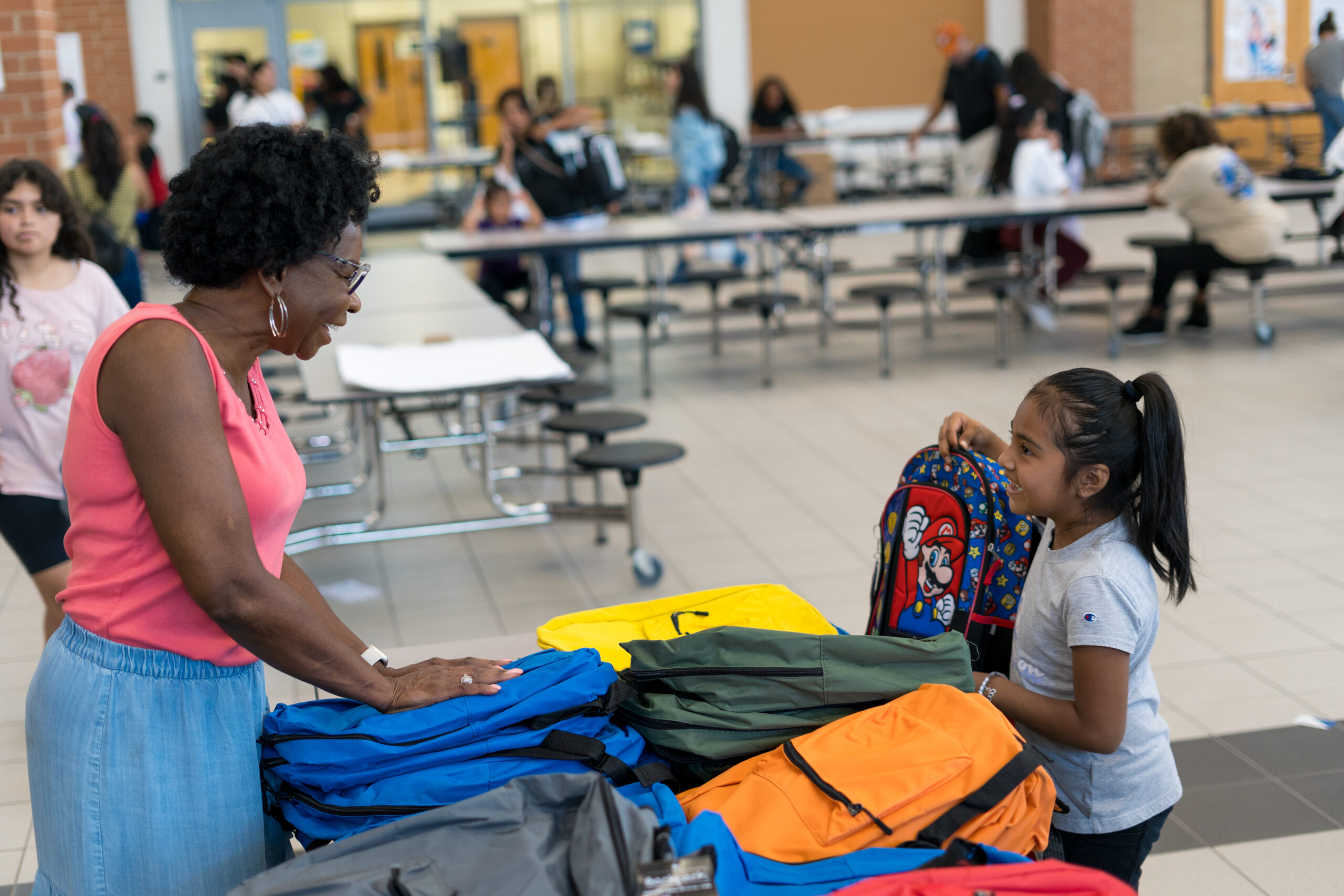 A young woman and a little girl in a school cafeteria