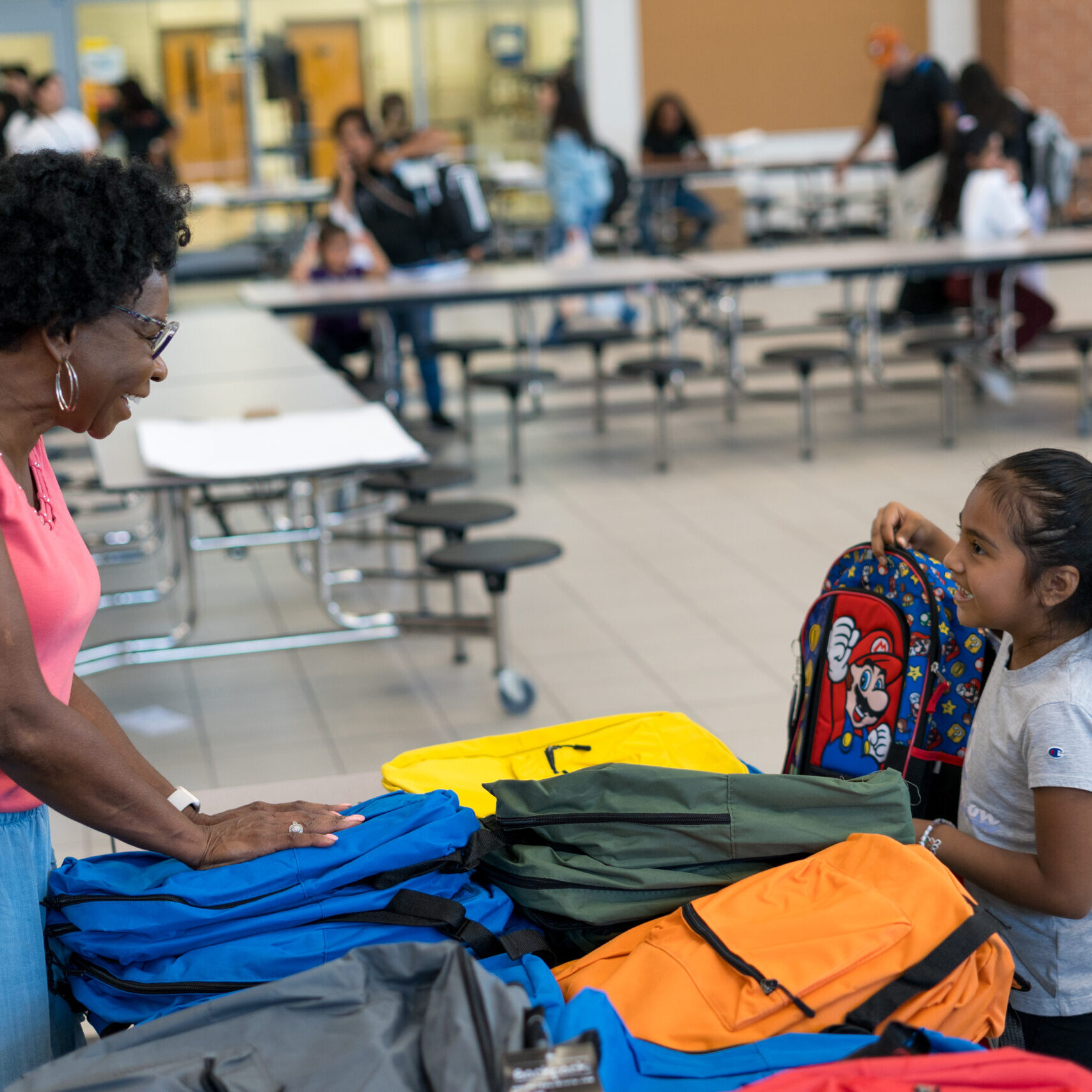 A young woman and a little girl in a school cafeteria